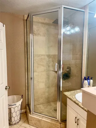 a bathroom with a granite countertop sink toilet and shower