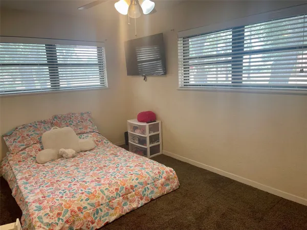 a bedroom with a bed dresser and a window
