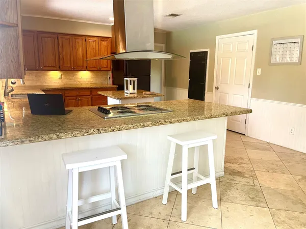 a kitchen with granite countertop a sink a stove and cabinets