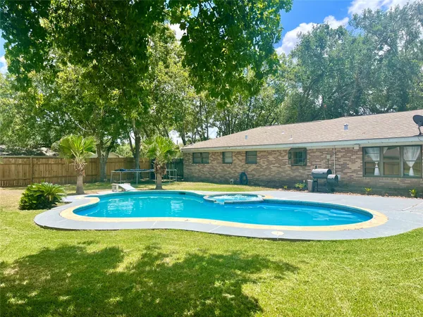 a view of a house with swimming pool and a yard