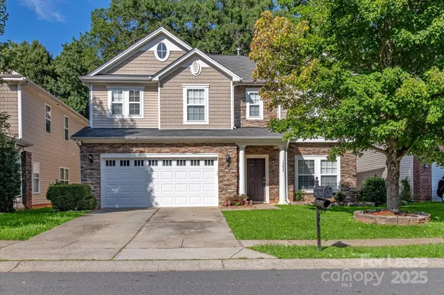 a front view of a house with a garden and plants