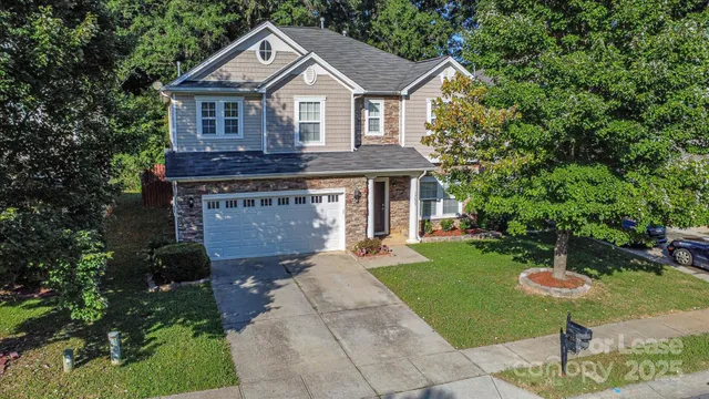 a front view of a house with a yard and garden