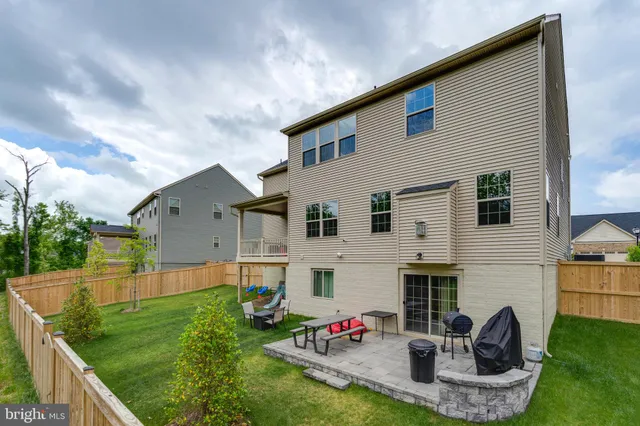 a view of backyard with table and chairs and wooden fence