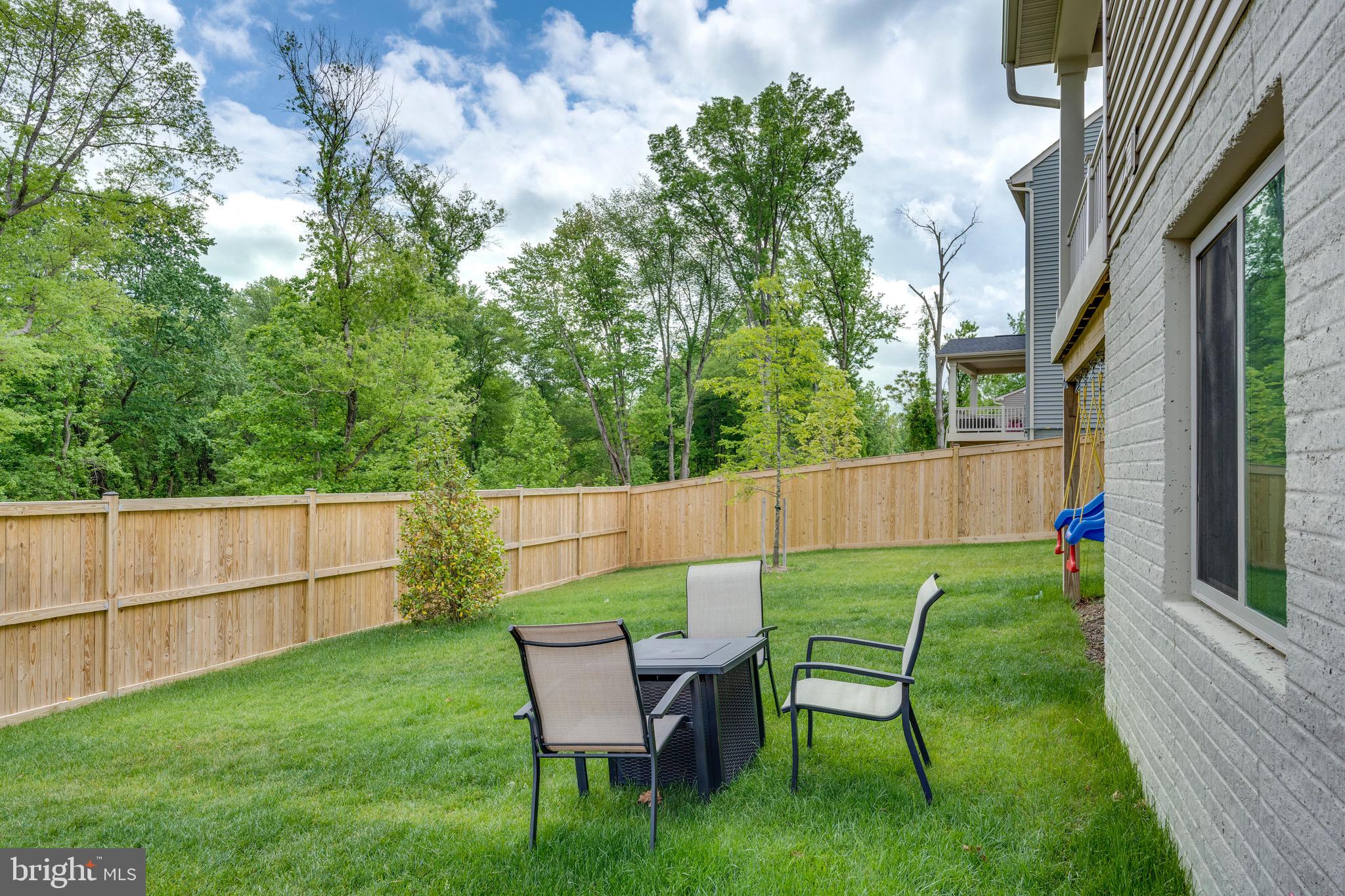 9004 Cavesson Way Upper Marlboro, MD 20772 - Photo 31 of 60 a view of backyard with table and chairs and wooden fence