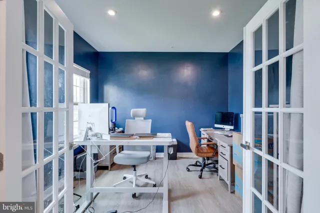 a kitchen with stainless steel appliances granite countertop a stove a sink a refrigerator a dining table and chairs with wooden floor