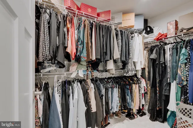 a view of walk in closet with clothes
