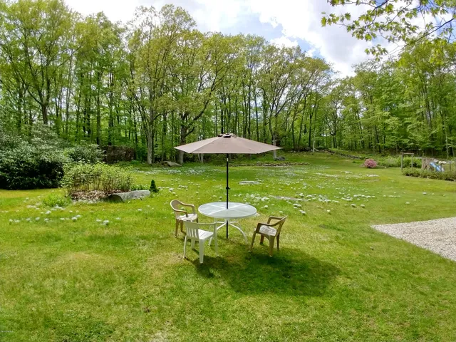 a backyard of a house with table and chairs