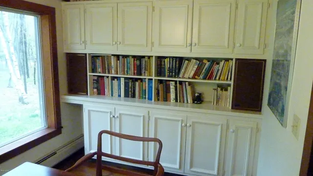 a shelf with books and a window