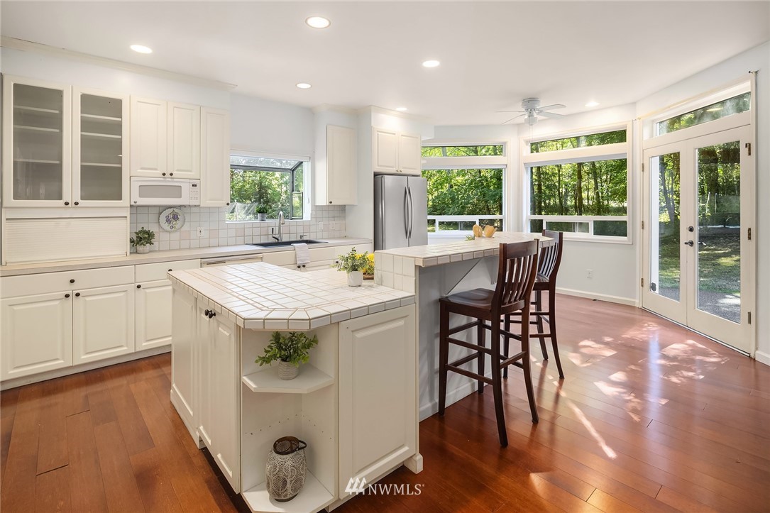 16425 Southeast Jones Road Renton, WA 98058 - Photo 8 of 40 a kitchen with a stove a sink a dining table and chairs