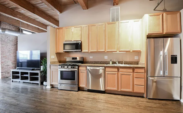 a kitchen with stainless steel appliances a stove a sink and a refrigerator