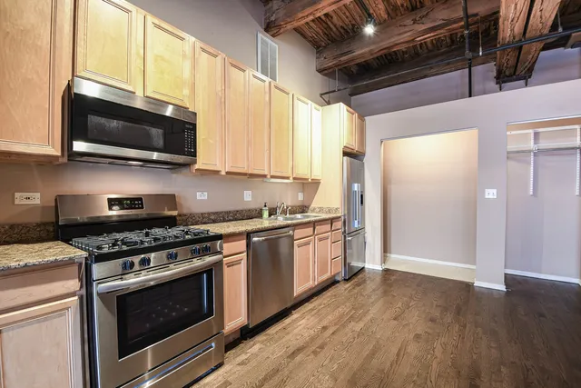a kitchen with stainless steel appliances granite countertop wooden cabinets stove top oven and sink