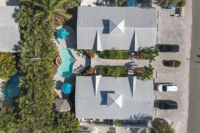 an aerial view of a house with a yard and large trees