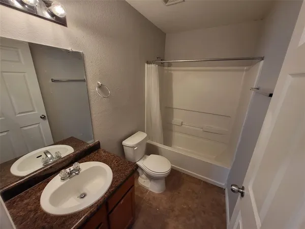 a view of swimming pool with seating area and trees in the background