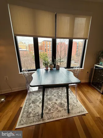 a view of a living room with a rug and wooden floor