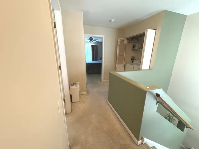 a view of a hallway with furniture and wooden floor
