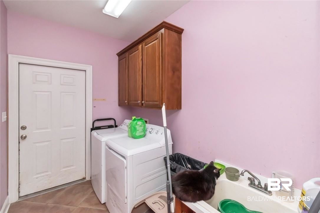 7170 Pierson Drive Mobile, AL 36619 - Photo 20 of 29 Laundry room featuring washer and dryer, cabinets, sink, and light tile patterned flooring