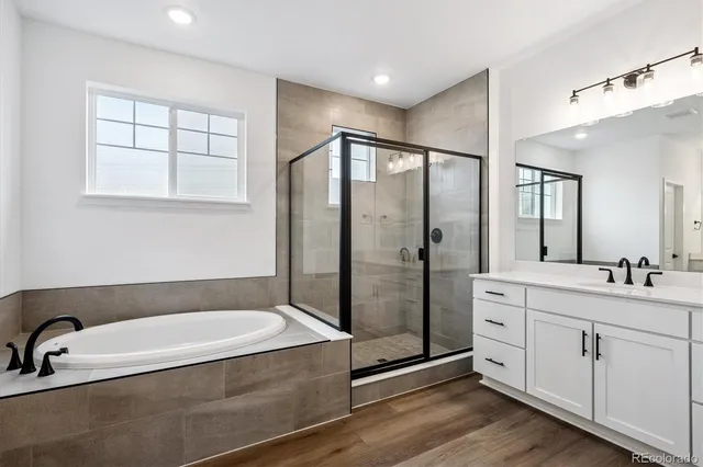 a bathroom with a tub a sink and mirror