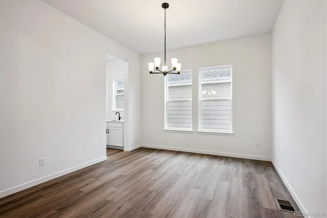 a view of a room with wooden floor chandelier and window