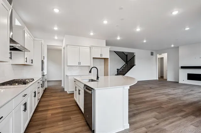 a large kitchen with stainless steel appliances granite countertop a sink and cabinets