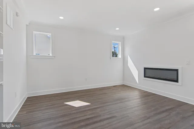 a view of empty room with wooden floor and entryway