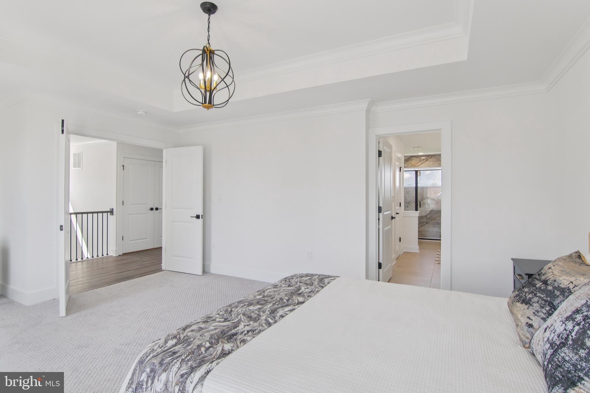 9838 Legion Street, Unit 3 Philadelphia, PA 19114 - Photo 39 of 51 a bedroom with a bed and a chandelier