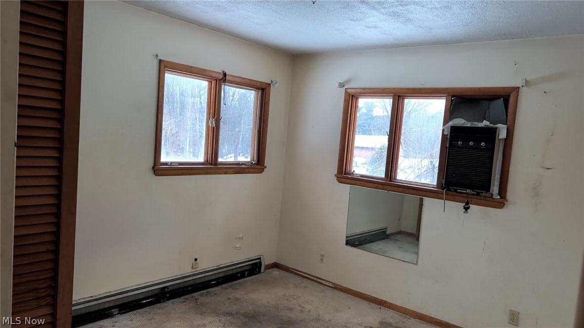 1078 Aberagg Road Atwater, OH 44201 - Photo 9 of 14 Unfurnished room featuring cooling unit, baseboard heating, and a textured ceiling