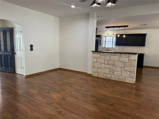 wooden floor in an empty room with a kitchen