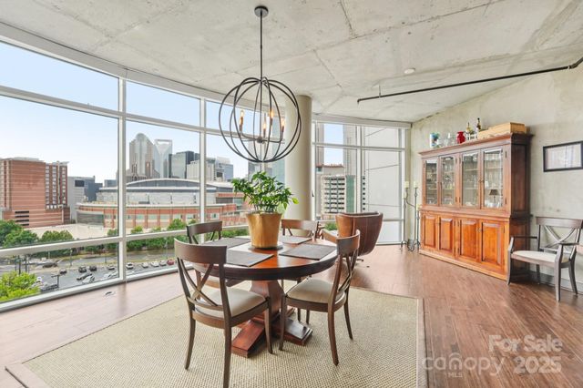 a view of a dining room and livingroom with furniture wooden floor a chandelier