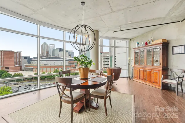 a view of a dining room and livingroom with furniture wooden floor a chandelier