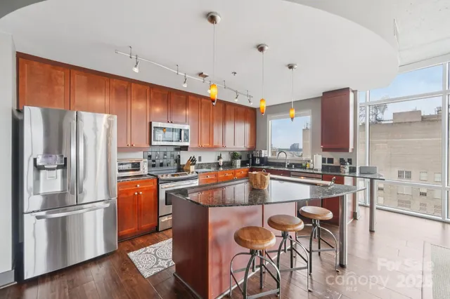 an open kitchen with wooden floor and large window