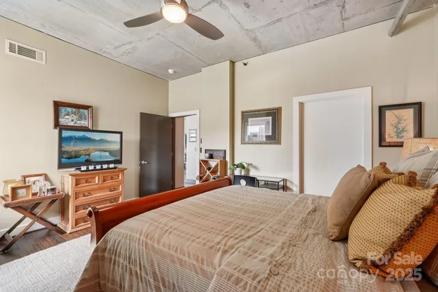 a bedroom with a bed and a large mirror on the dresser