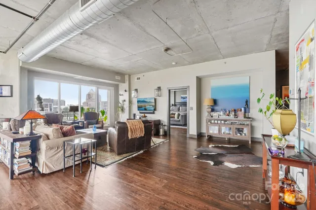 a living room with furniture kitchen view and a large window