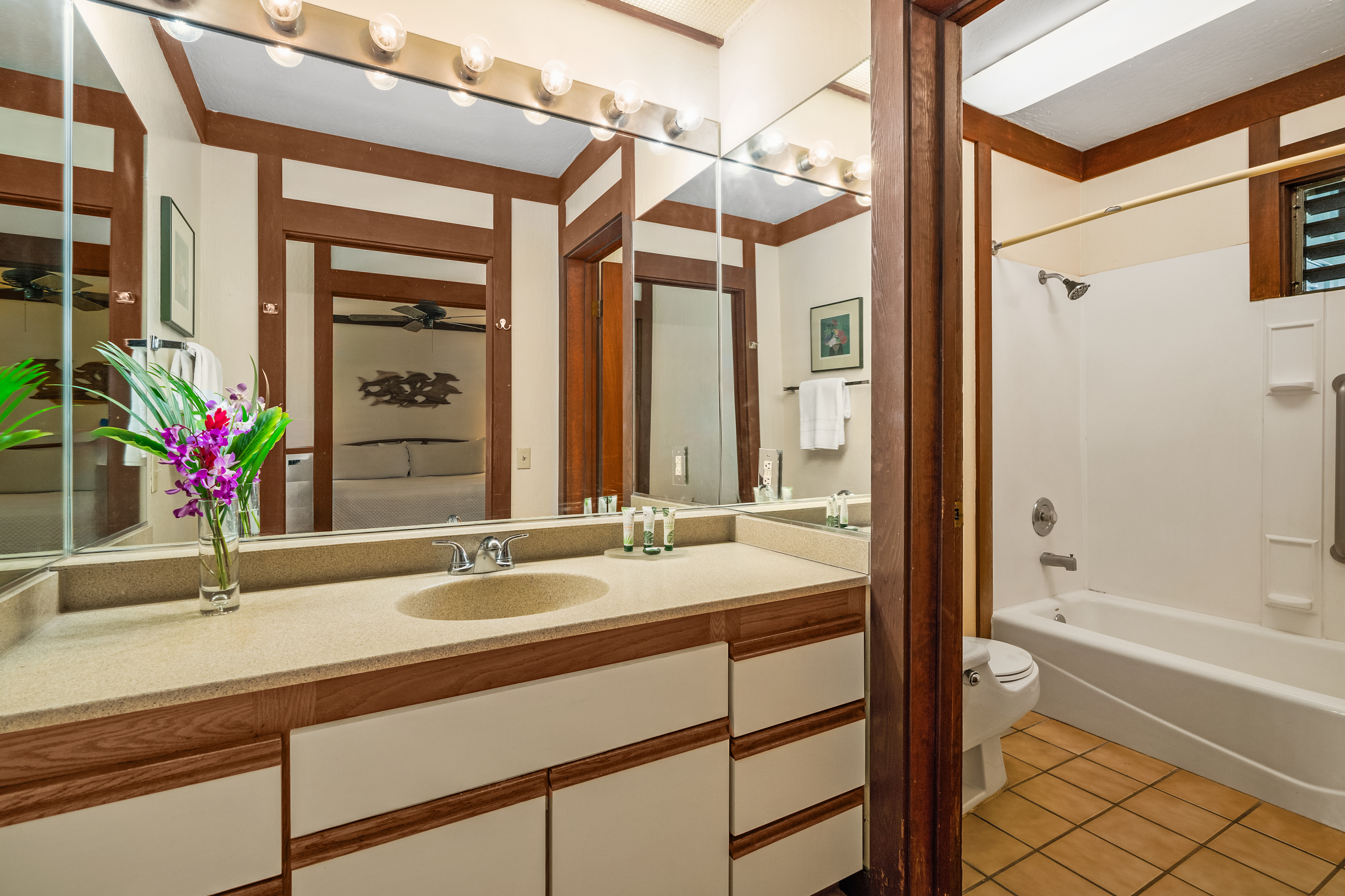 2253 Poipu Road, Unit 67 Koloa, HI 96756 - Photo 14 of 24 a bathroom with a granite countertop sink and a large mirror