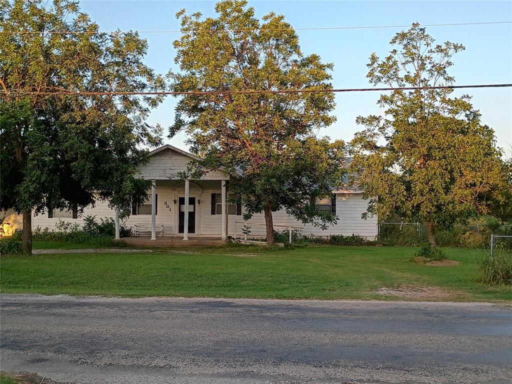 301 Withers Road Mineral Wells, TX 76067 - Photo 1 of 7 a front view of a house with a garden and trees