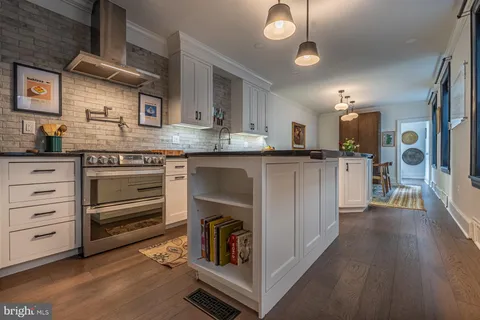 a kitchen with stainless steel appliances granite countertop a stove and cabinets