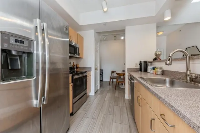 a kitchen with stainless steel appliances granite countertop a refrigerator and a sink