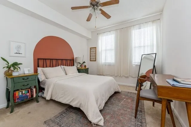 a bedroom with a bed a dresser and a window