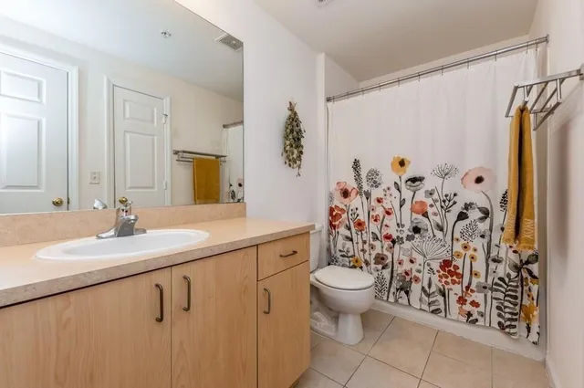 a bathroom with a granite countertop sink a toilet and a mirror