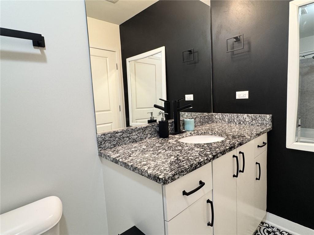 250 Pharr Road Northeast, Unit 601 Atlanta, GA 30305 - Photo 18 of 34 a bathroom with a granite countertop sink and a mirror