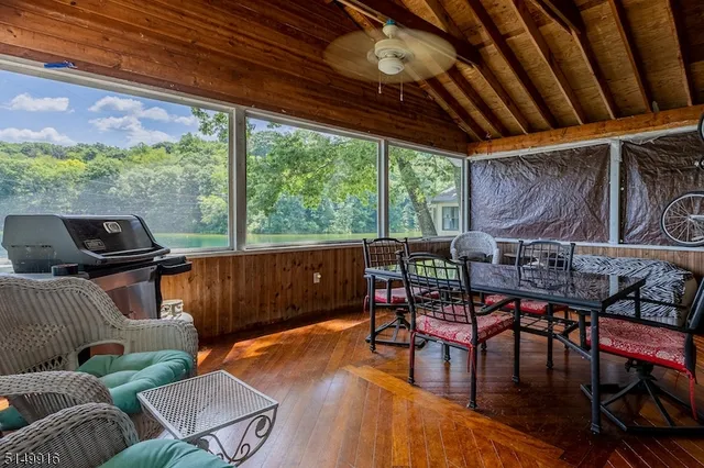a view of a patio with table and chairs with wooden floor and fence