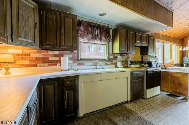 a kitchen with stainless steel appliances granite countertop a sink stove and cabinets