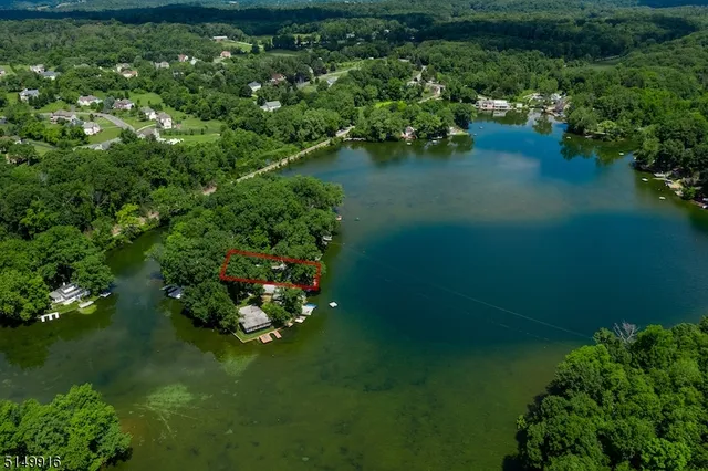 a backyard of a house with lots of green space and lake view