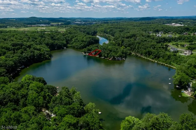 an aerial view of a houses with a yard and lake view