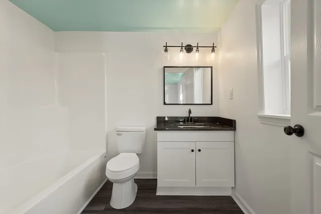 a bathroom with a toilet sink and mirror