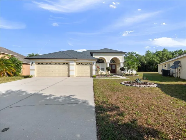a view of a house with a yard and a garage