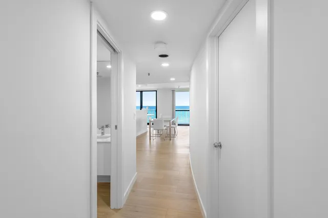 a view of a hallway with wooden floor windows and a room