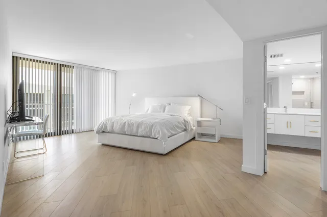 a living room with a bed furniture and a wooden floor