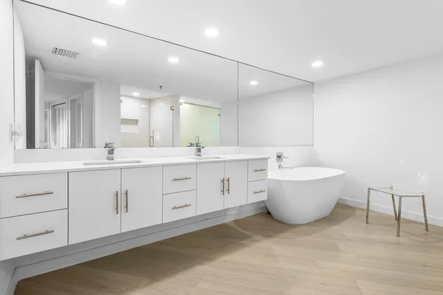 a large bathroom with a double vanity sink a mirror and a