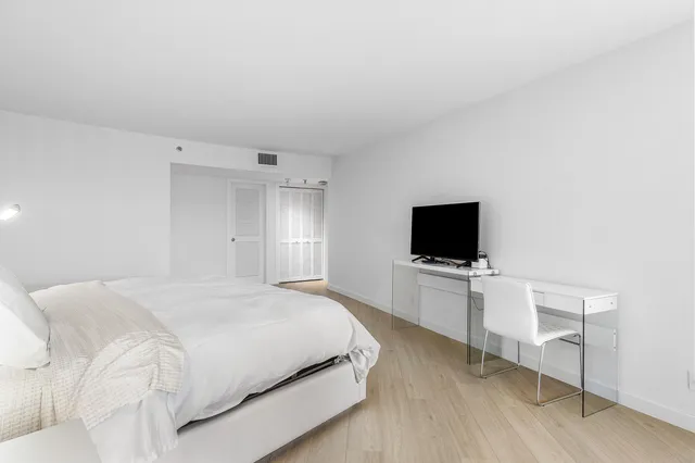 a bedroom with a bed and a flat screen tv