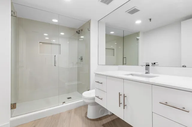 a bathroom with a bathtub shower sink mirror and toilet